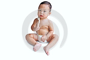 Cute little asian boy is wearing a diaper and playing on white