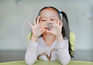 Cute little Asian child girl holding alphabet EF Executive Functions text on her face. Education and development concept