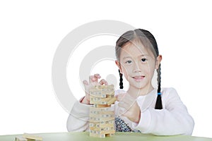 Cute little Asian child girl playing wood blocks tower game for Brain and Physical development skill in a classroom. Focus at