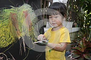Cute little asian girl enjoying arts and crafts painting