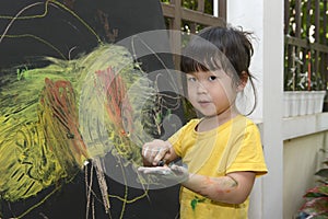 Cute little asian girl enjoying arts and crafts painting