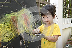 Cute little asian girl enjoying arts and crafts painting