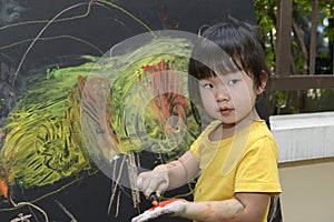 Cute little asian girl enjoying arts and crafts painting