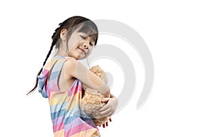 Cute little Asian girl hugging her favourite brown teddy bear and smiling in white background.