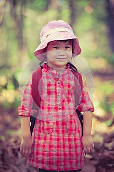 Cute little asian girl looking at camera and smiling over nature