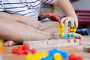 Cute little Asian girl playing with colorful toy blocks. Educational and creative toys and games for young children