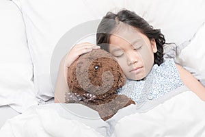 Cute little asian girl sleep and hug teddy bear