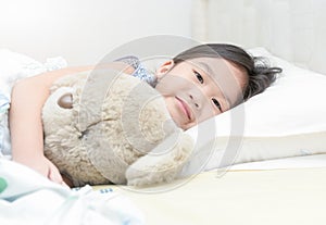 Cute little asian girl smile and hug teddy bear