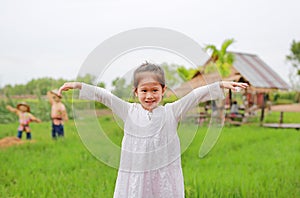 Cute little Asian girl Stretch arms at the fresh green paddy fields