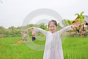 Cute little Asian girl Stretch arms at the fresh green paddy fields