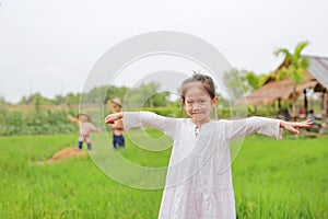 Cute little Asian girl Stretch arms at the fresh green paddy fields