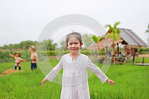 Cute little Asian girl Stretch arms at the fresh green paddy fields
