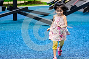 Cute little asian kid girl while running and enjoying on a playground