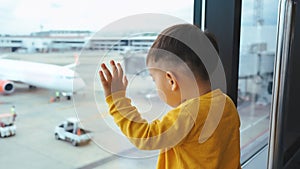 Cute Little Asian little child boy looking out of terminal window