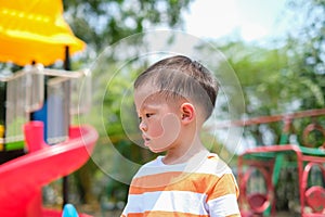 Cute little Asian 2 - 3 years old toddler boy child sweating during having fun playing, exercising outdoor at playground, Heat photo