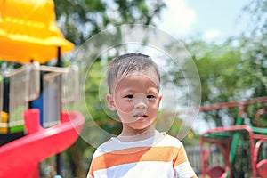 Cute little Asian 2 - 3 years old toddler boy child sweating during having fun playing, exercising outdoor at playground, Heat