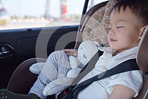 Asian 2 - 3 years toddler baby boy child sleeping in modern car seat. Child traveling safety on the road