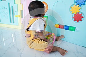 Cute little asin baby boy playing with wooden toy at room