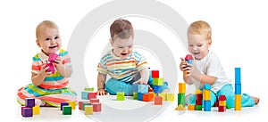 Cute little babies playing with toys or blocks and having fun while sitting on floor isolated over white background