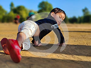 Cute little baby boy crawling in a park. Child crawling in a public park and looking back. View from back. Copy space Selective