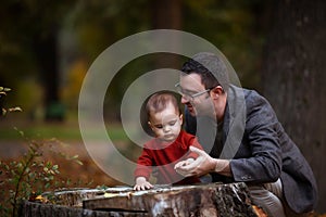 Cute little baby boy and his father. Dad and son having fun on autumn day in city park