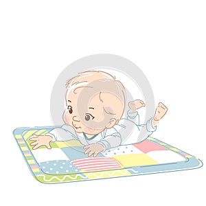 Cute little baby boy laying on stomach, on playing mat.