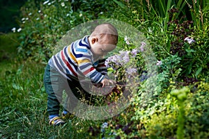 Cute little baby boy outdoors. Happy smiling baby at green garden