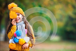 Cute little baby girl play in autumn park with fallen leaves