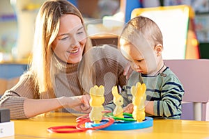 Cute little baby boy playing with his mother with rings