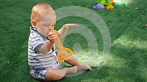 Cute little baby boy, playing with toys outdoors, sunny kids.