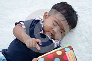 Cute little baby boy reading the book