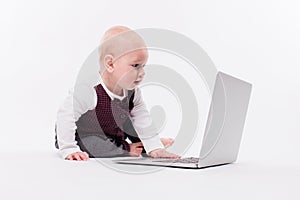 Cute little baby boy sitting on a white background in front of a