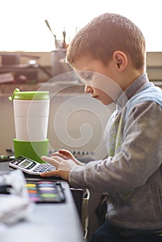 Cute little baby boy using a calculator
