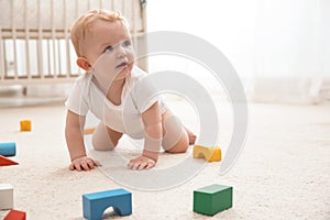 Cute little baby crawling on carpet indoors