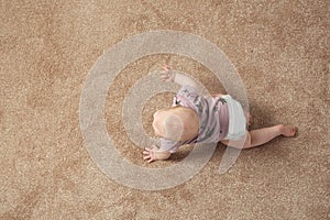 Cute little baby crawling on carpet indoors, with space for text