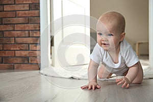 Cute little baby crawling on floor indoors