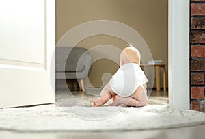 Cute little baby crawling on rug indoors