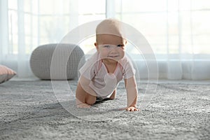 Cute little baby crawling on soft carpet