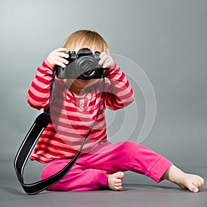 Cute little baby with digital photo camera