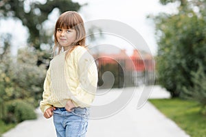 Cute little baby girl 4-5 year old wear casual clothes walk in park outdoor. Looking at camera. Springtime.