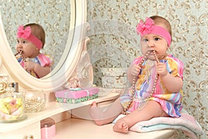 Cute little baby girl in front of mirror