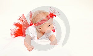 Cute little baby girl lying in red skirt