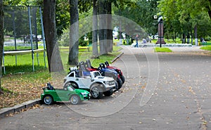 Cute little baby girl playing with blue small toy car in garden of home or nursery. background