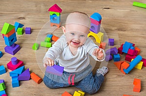 Cute little baby girl playing with colorful toy blocks