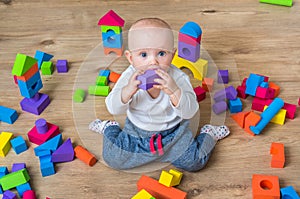 Cute little baby girl playing with colorful toy blocks