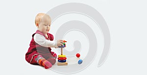 Cute little baby girl playing with a colorful wooden toys.