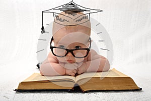 Cute little baby in glasses with painted professor hat photo