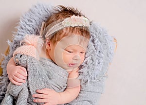 Cute little baby with knitted toy bunny lying