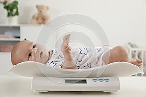 Cute little baby lying on scales