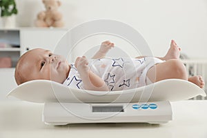 Cute little baby lying on scales